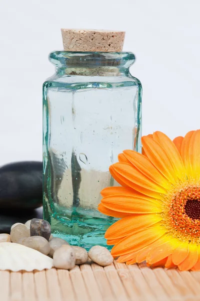 Ein Glaskolben mit runden, glatten Kieseln und einer Sonnenblume — Stockfoto
