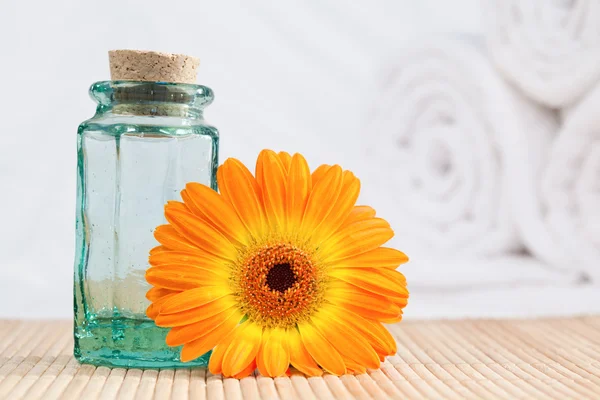 Eine Glasflasche und eine Sonnenblume mit weißen Handtüchern — Stockfoto