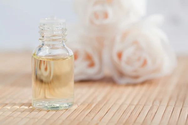 Roses and a glass phial with on a focus on the phial — Stock Photo, Image