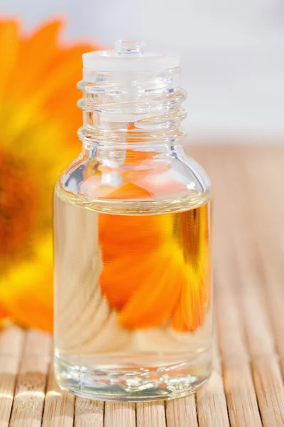Glass phial and a sunflower — Stock Photo, Image