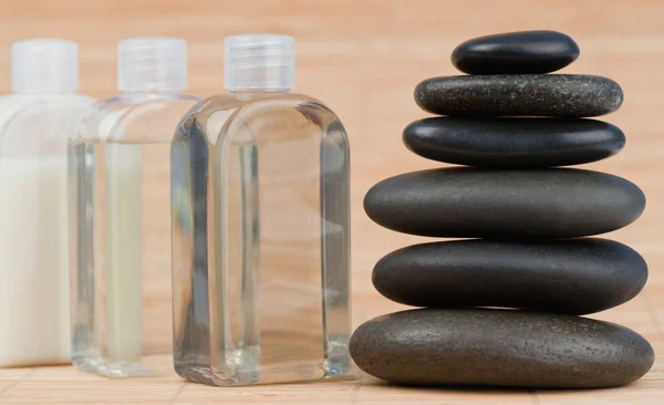Close up of glass flasks and a black stones stack — Stock Photo, Image