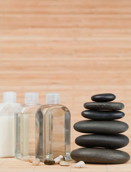 Glass flasks with pebbles and a black stones stack — Stock Photo, Image