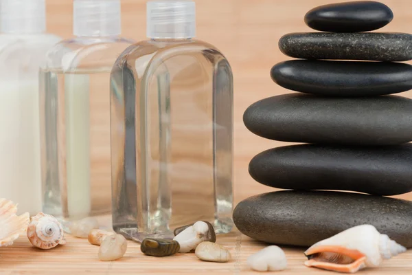 Close up of pebbles with a black pebbles stack and glass flasks — Stock Photo, Image