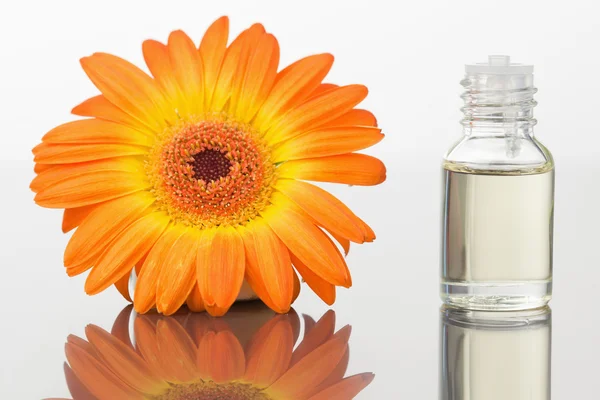 一个玻璃药瓶和橙色非洲菊 — 图库照片
