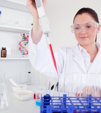 Cute female biologist holding a manual pipette with sample from clipart