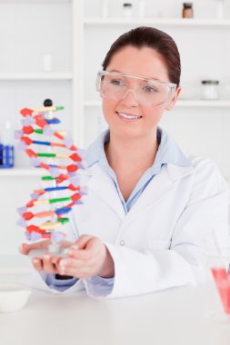 Cute scientist showing the dna double helix model clipart