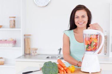 Charming woman using a blender clipart