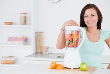 Dark-haired woman posing with a blender clipart