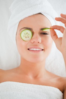 Young woman with cucumber slices on the face clipart