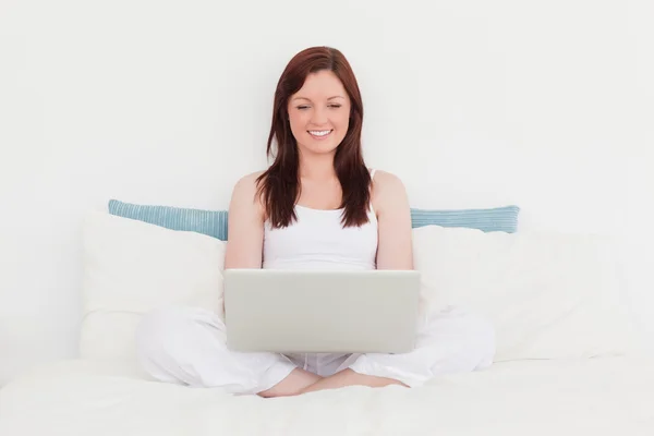 Wspaniały rudowłosa kobieta relaksując się przy jej laptop podczas sittin — Zdjęcie stockowe