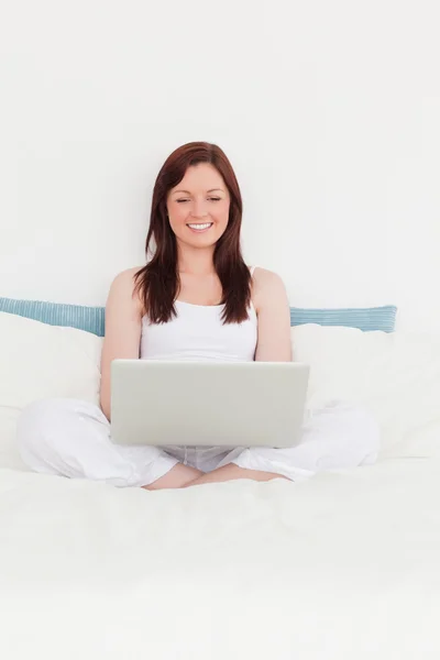 Mignonne femme aux cheveux roux se détendre avec son ordinateur portable tout en étant assis sur — Photo