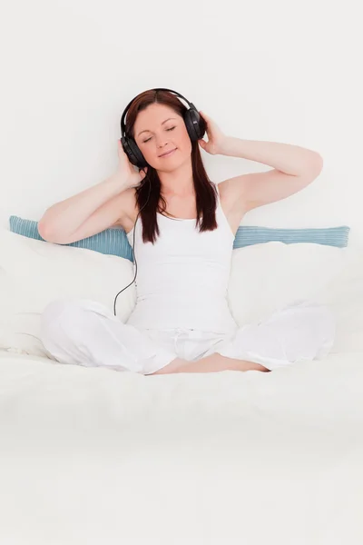 Prachtige roodharige vrouw luisteren naar muziek met haar koptelefoon — Stockfoto