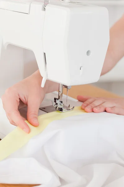 Caucasian hands using a sewing machine in the living room — Stock Photo, Image