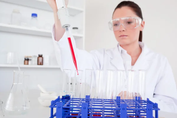 Pretty female biologist holding a manual pipette with sample fro — Stock Photo, Image