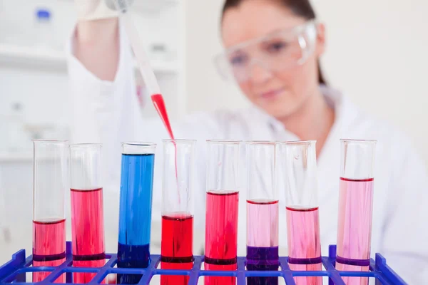 Attractive red-haired scientist filling up a test tube — Stock Photo, Image