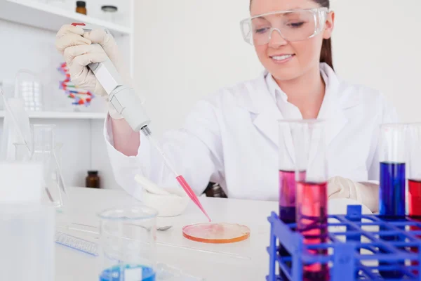 Pretty red-haired scientist using a pipette — Stock Photo, Image