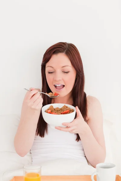 Bella donna dai capelli rossi che fa colazione mentre si siede — Foto Stock