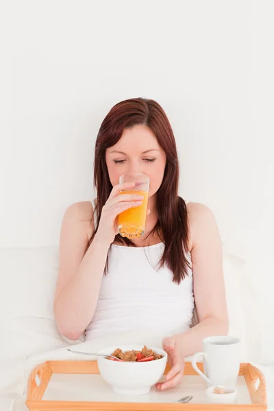 Atrakcyjna kobieta Ruda picia szklankę pomarańczowy sok wh — Zdjęcie stockowe
