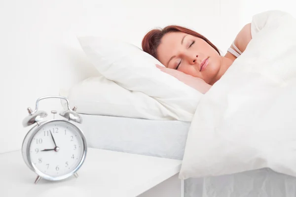 Attraktiva rödhårig kvinna sover i sin säng — Stockfoto