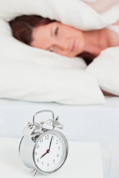 Piękna rudowłosa kobieta budzi się dzięki budzik — Zdjęcie stockowe