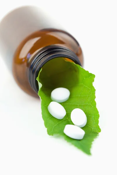 Foglia e pillole in una piccola bottiglia — Foto Stock