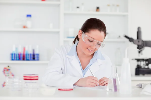 Junge Wissenschaftlerin schreibt einen Bericht — Stockfoto