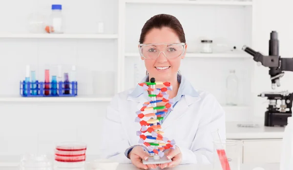 Gyönyörű tudós mutatja a DNS dupla hélix modell — Stock Fotó