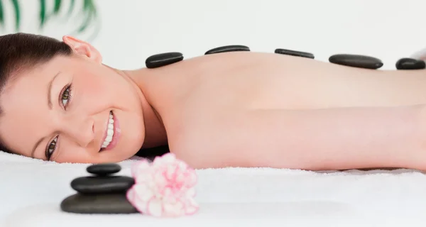Rothaarige Frau erhält eine Massage mit heißen Steinen — Stockfoto