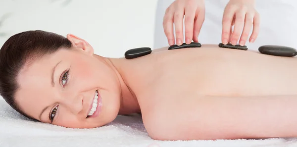 Smiling woman receiving a hot stone massage — Stock Photo, Image
