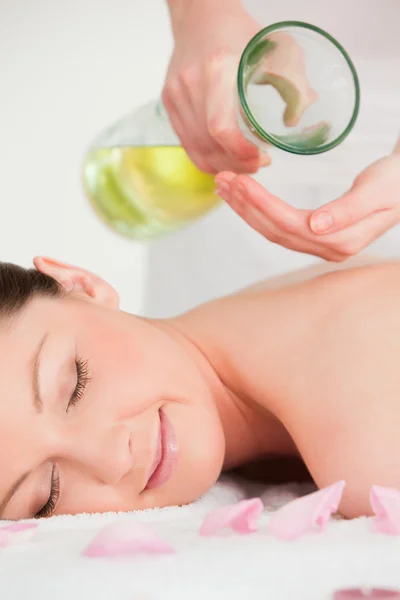 Portrait d'une femme heureuse ayant de l'huile de massage versé sur son dos — Photo