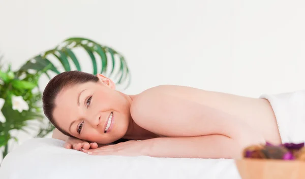 Усміхнена жінка на масажному столі — стокове фото