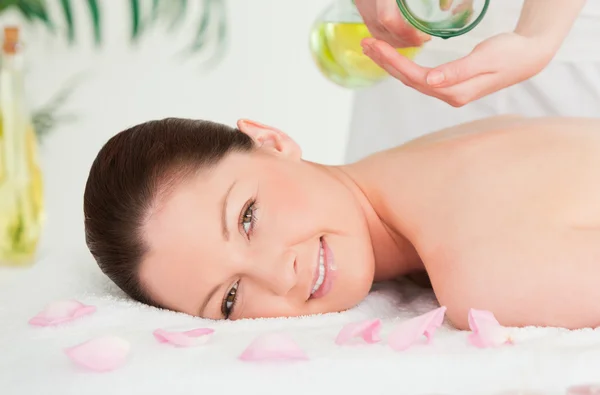Beautiful woman getting massage oil on her back in a spa — Stock Photo, Image