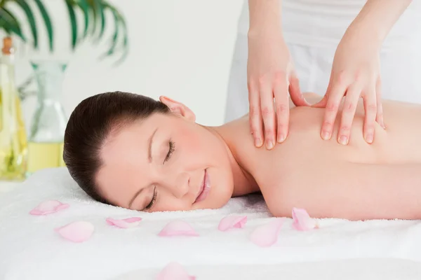 Cute woman closing her eyes during a massage — Stock Photo, Image