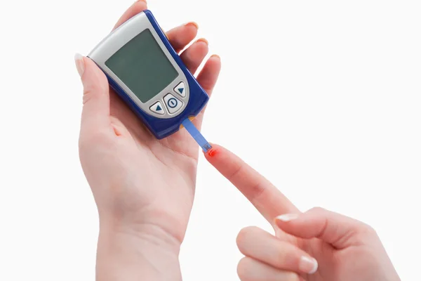 Young woman using a blood glucose meter — Stock Photo, Image