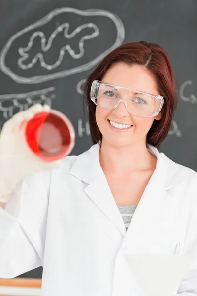 Cientista de cabelos vermelhos sorridente olhando para uma placa de Petri — Fotografia de Stock