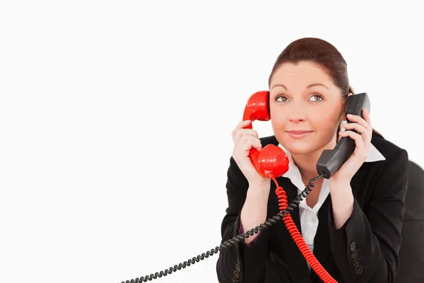 Drăguţă secretară care răspunde la două telefoane în acelaşi timp. — Fotografie, imagine de stoc