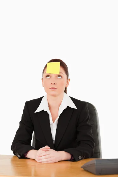 Businesswoman looking at the sign on her forehead — Stock Photo, Image