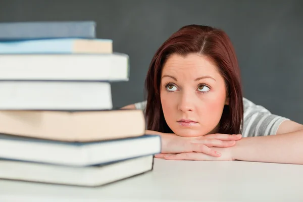 Verzweifelte Studentin schaut auf ihre Bücher — Stockfoto