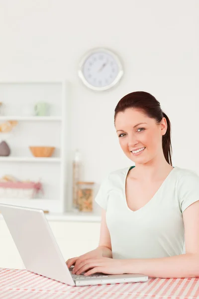 Vacker kvinna poserar medan du kopplar av på sin laptop — Stockfoto