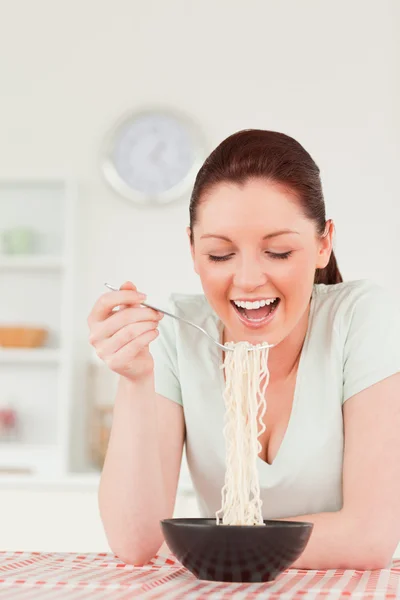 Piękna kobieta pozowanie podczas jedzenia makaronu — Zdjęcie stockowe