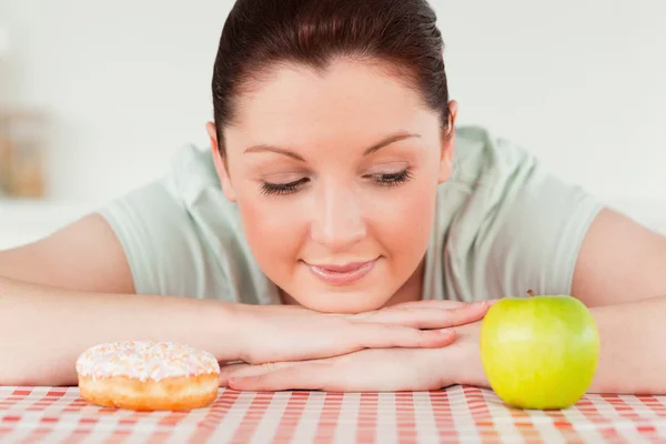 Good looking woman posing with a donut and a green apple — Stock Photo, Image