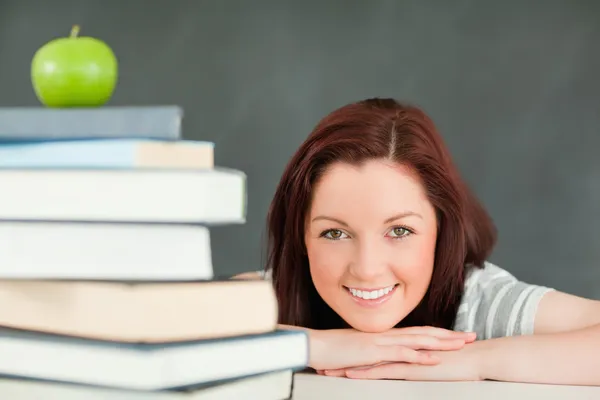 Ung student med ett äpple och böcker i förgrunden — Stockfoto