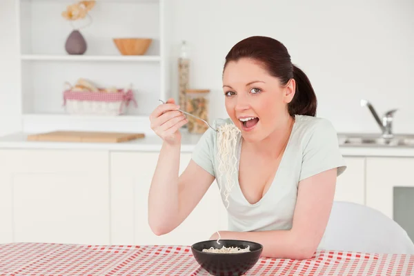 Beautiful woman posing while eating a bowl of pasta — Stock Photo, Image