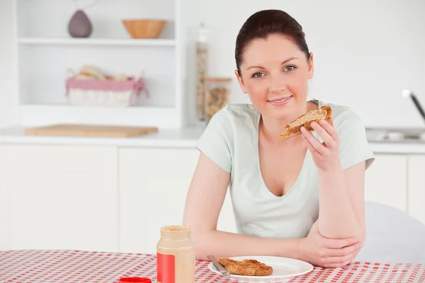 Schöne Frau posiert beim Essen einer Scheibe Brot — Stockfoto