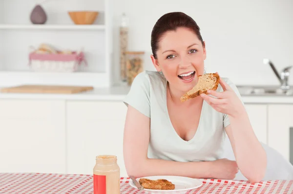 Mujer guapa posando mientras come una rebanada de pan — Foto de Stock