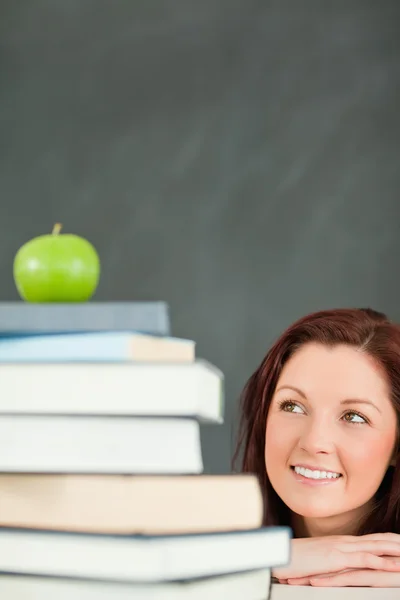 Ritratto di un giovane studente che guarda la mela sulla cima di h — Foto Stock