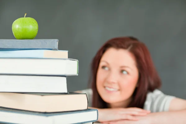 Jonge vrouwelijke student met een stapel boeken — Stockfoto
