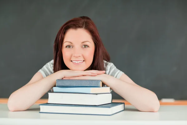 Giovane studentessa con il mento sui suoi libri — Foto Stock
