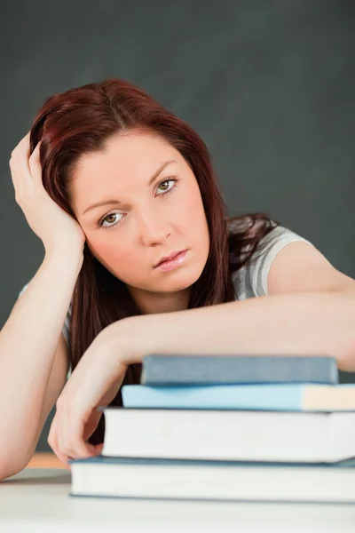 Primer plano de una estudiante cansada con su antebrazo en sus libros — Foto de Stock