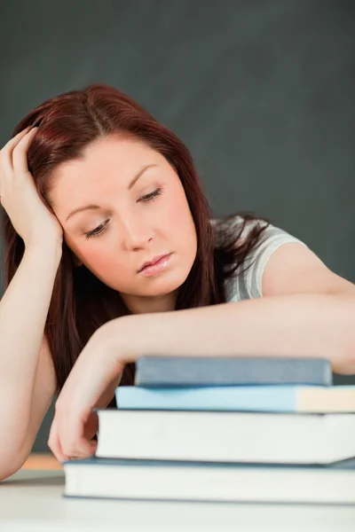 Jeune étudiante endormie avec son avant-bras sur ses livres — Photo